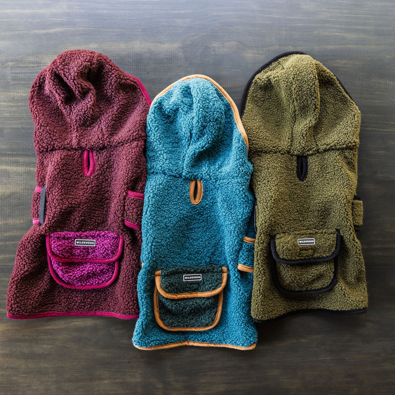 Three Sherpa Jackets in burgundy, teal, and olive, with hoods, back pockets, and Velcro straps.